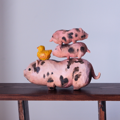 Hand-carved wooden pig family stacked on a shelf - mother pig, piglets and yellow chick figurines by anornament