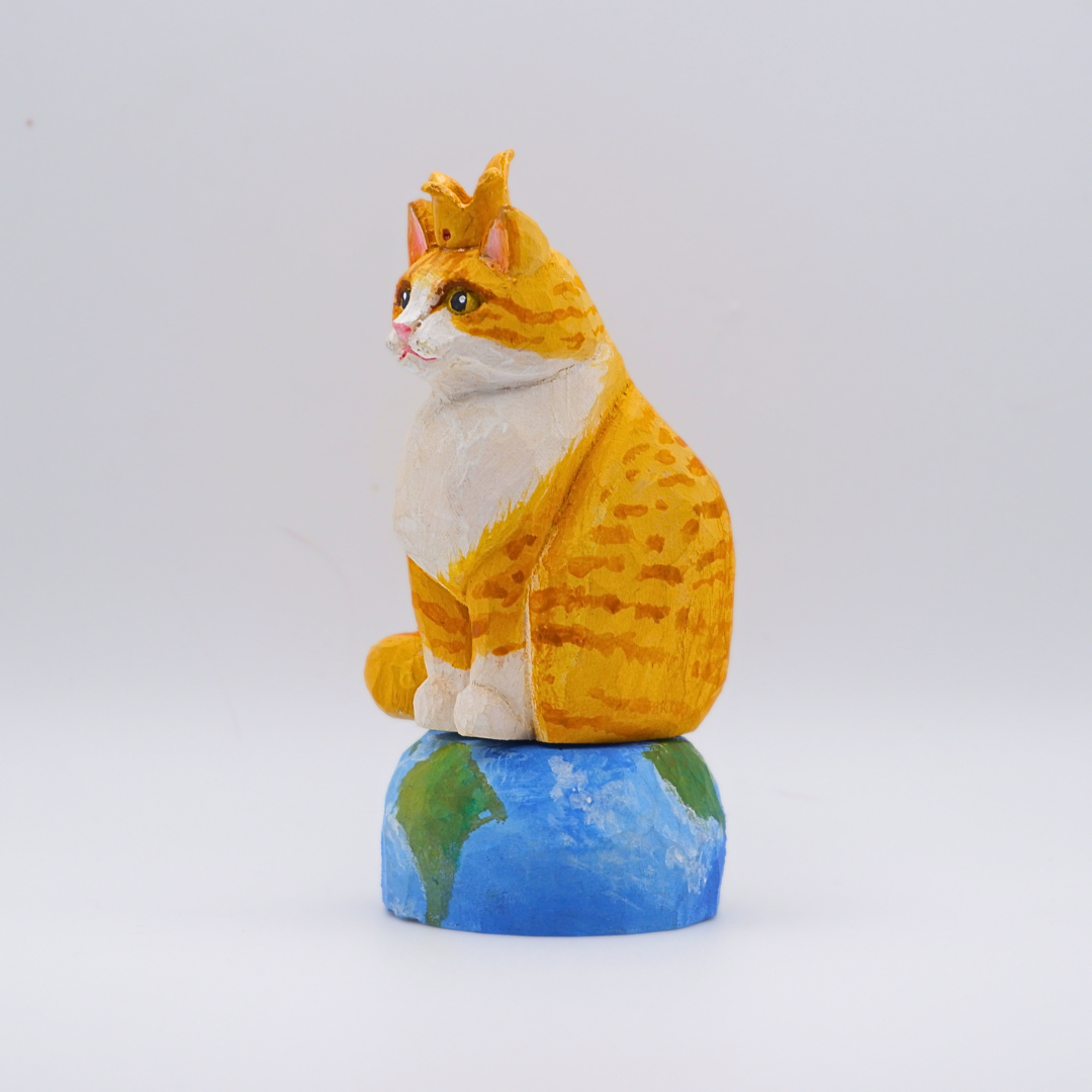 Hand-carved wooden Ginger cat figurine with gold crown seated on painted Earth globe base by anornament