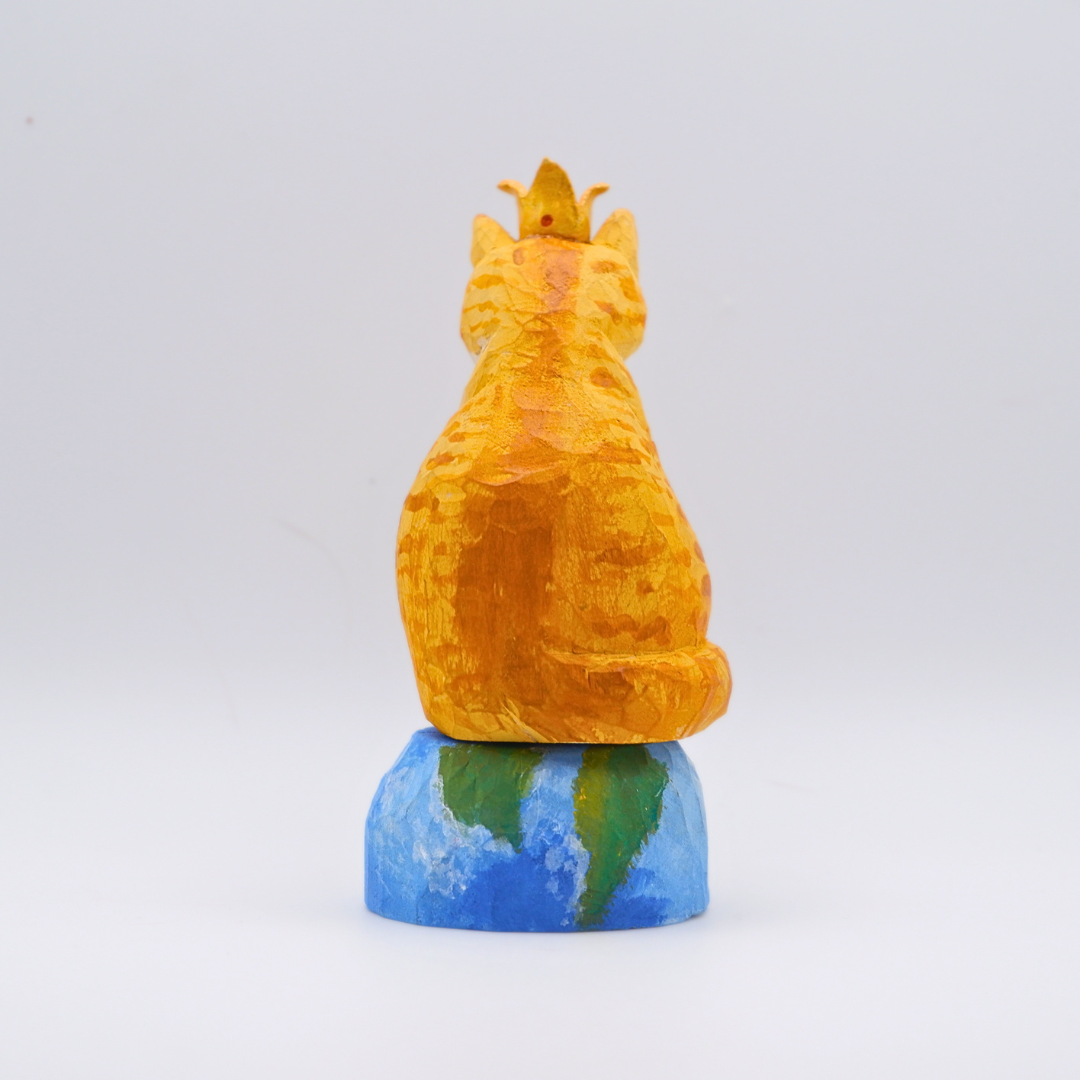 Hand-carved wooden Ginger cat figurine with gold crown seated on painted Earth globe base by anornament
